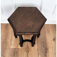 a small wooden table sitting on top of a hard wood floor