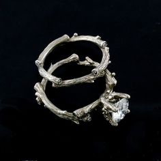 two silver rings with branches and a crystal stone