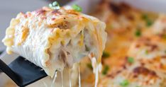 a close up of a person holding a piece of lasagna