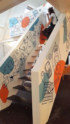 a woman sitting on top of a set of stairs next to a wall covered in doodles