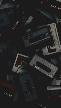 several old tape recorders scattered on top of each other in the middle of a dark room