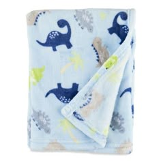 a blue blanket with dinosaurs on it and a white towel folded in the shape of a dinosaur