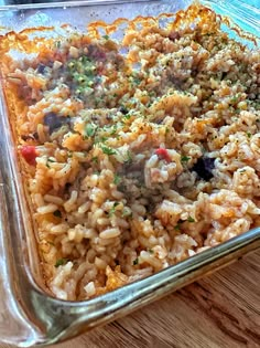 a casserole dish with meat and rice in it on a wooden table top