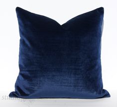 a blue velvet pillow on a white background