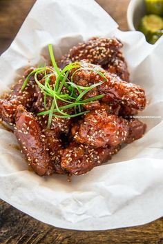 a close up of a plate of food with sesame seeds and meat in sauces