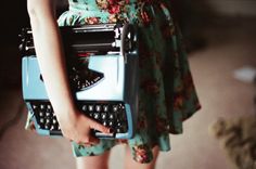 a woman holding an old fashioned typewriter with the words, a girl wrote it