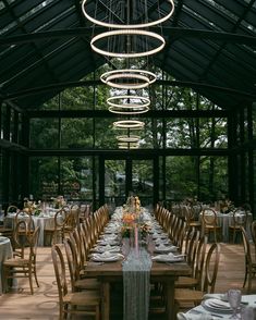 a dining room with tables and chairs set up for a formal function in front of a glass wall