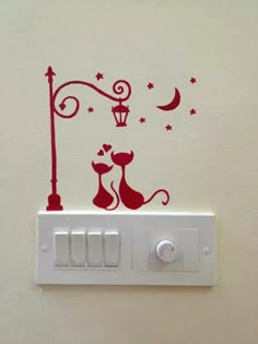 a white light switch with a red sticker on it's side and a cat sitting under a street lamp