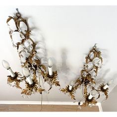 a chandelier hanging from the ceiling in a room with white walls and wood flooring