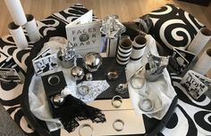 a black and white coffee table with silverware on it, surrounded by other decorative items