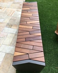 a wooden bench sitting on top of a lush green grass covered park area next to a brick walkway