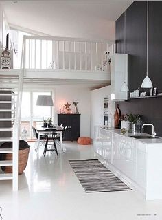 an open kitchen and living room with stairs leading up to the second floor above it