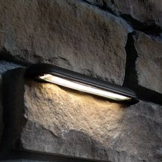 a light that is on the side of a stone wall