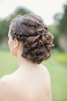 the back of a woman's head, with her hair in a low bun