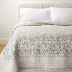 a bed with white sheets and pillows on top of it