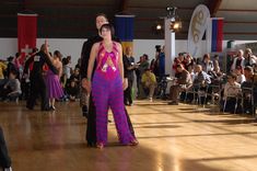 two people standing on a dance floor in front of an audience