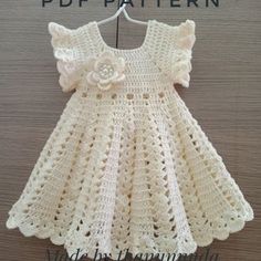 a crocheted baby dress with flowers on the front and back, made in germany