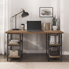 a laptop computer sitting on top of a wooden desk next to a lamp and bookshelf