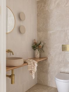 a bathroom with a sink, mirror and towel on the shelf in front of it