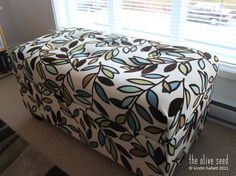 a footstool sitting in front of a window