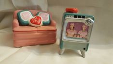 an old fashioned tv sitting next to a small toy oven