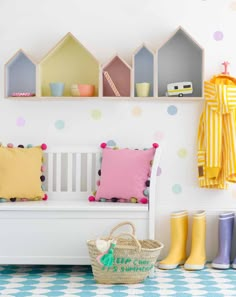 a white bench sitting in front of a wall filled with colorful pillows and umbrellas