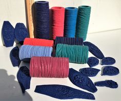 several different colors of thread on a white surface