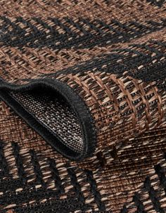 the fabric is woven in brown and black tones with an interesting pattern on it's side