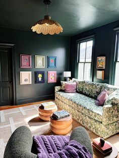 a living room filled with furniture and pictures on the wall above it's windows