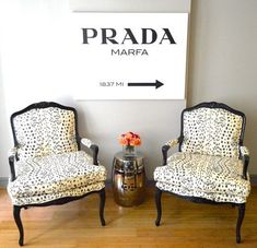 two chairs sitting next to each other in front of a sign that says prada marfa