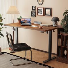 a computer desk with a laptop on top of it next to a lamp and potted plant