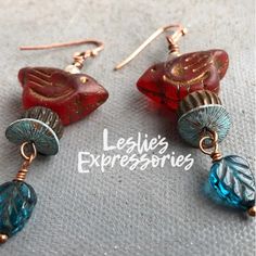 ◾red Czech glass bird beads with teal blue leaf dangles. Wood bead, patina spacers and soft blue accent beads on a copper plated ear wire. ...in the Garden is a colorful and whimsical collection of jewelry that shares a theme of flowers, birds, insects and other things you see in a garden. Beads are mostly Czech glass or Art beads made in ceramic, clay, resin or painted metals. Ear wires are usually plated metal to keep price down. If you would like to upgrade ear wires just let me know in the c Metal Clay Art, Earrings Bird, Mama Bird, Bird Beads, Blue Accent, Red Bird, Make Your Own Jewelry, Spring Jewelry, Red And Teal