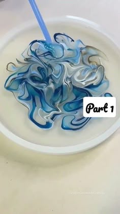 a white plate with blue swirls on it and a blue toothbrush in the bowl