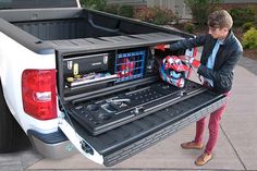 a man loading his truck with tools in the bed and tool box on the back