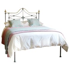 a bed with white linens and pillows on it's headboard, in front of a white background