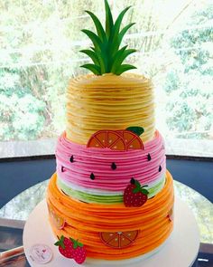 a multi layer cake decorated with fruit and pineapples