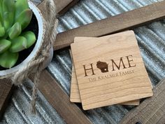 wooden coasters with the words home on them next to a potted succulent