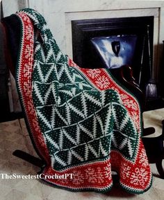 an afghan is sitting in front of a fireplace