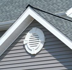 the roof of a house with a weather vein on it's shingled dormer