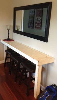 there is a bench with stools underneath the mirror