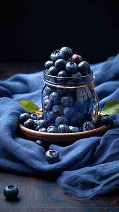 a glass jar filled with blueberries on top of a wooden table