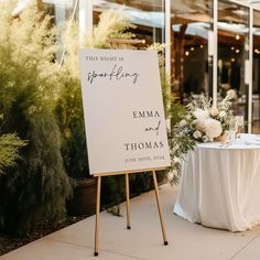 a sign that is sitting on top of a table with flowers in front of it