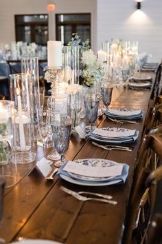 a long table is set with place settings and candles