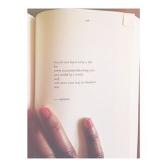 two hands holding an open book with a quote on it