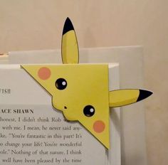 an open book with a paper pikachu on it