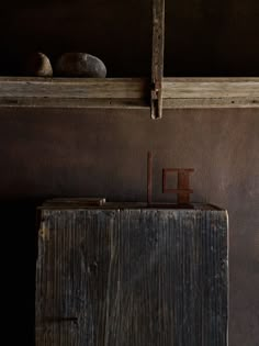 an old wooden cabinet and some rocks on the ledges in a room with brown walls