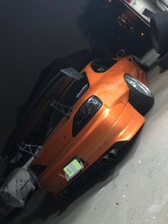 an orange sports car parked in a garage