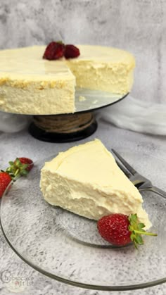 a piece of cheesecake on a glass plate with strawberries next to the cake