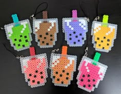 six perler bead keychains with different colored drinks on them, all in the same pattern