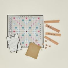 the scrabble game is laid out on a white surface with wooden pegs